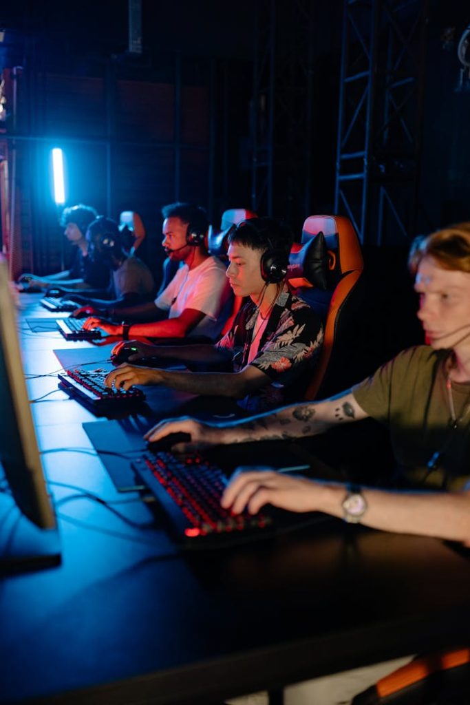 A group of young adults engaged in competitive gaming at a cybercafe.